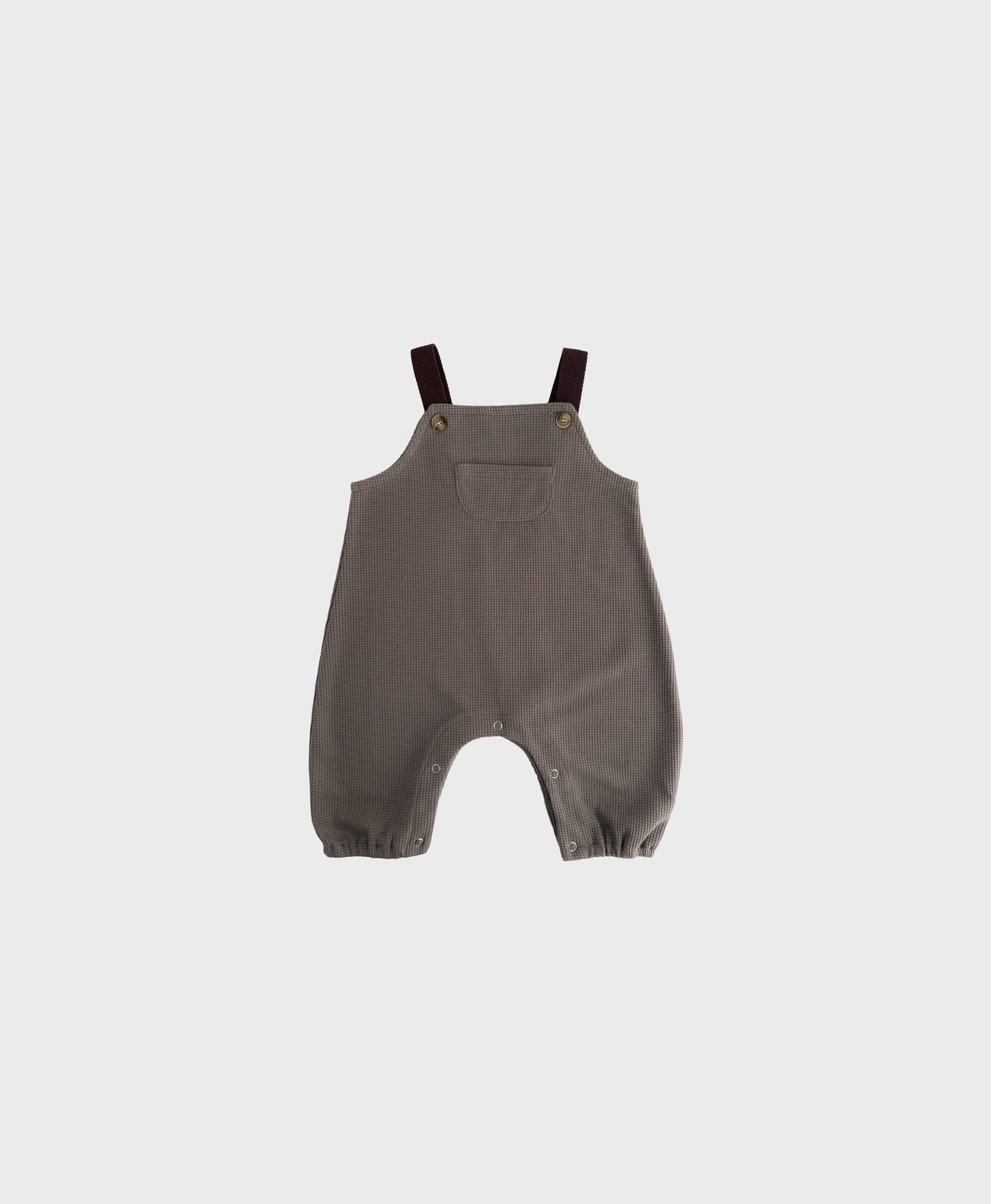 Brown sleeveless overall with brown straps for hip baby boy with snap buttons.