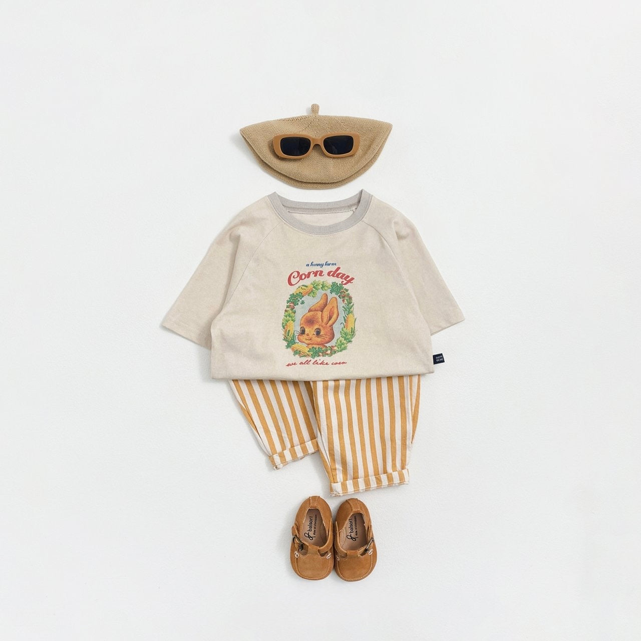 Toddler's outfit with a shirt, striped pants, shoes, and a hat