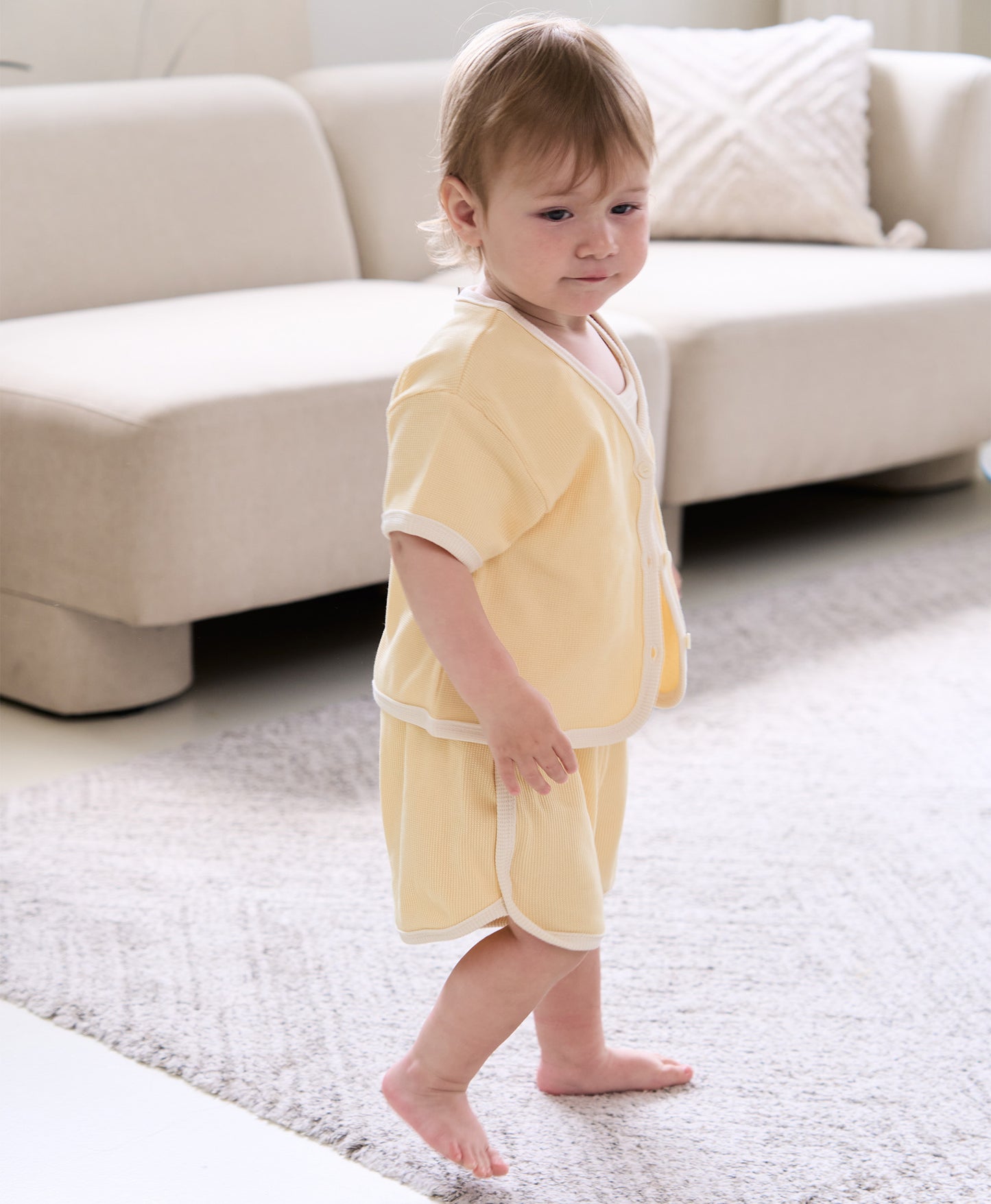 Toddler dressed in a stylish waffle-textured Korean baby clothes set, posing in a clean indoor space