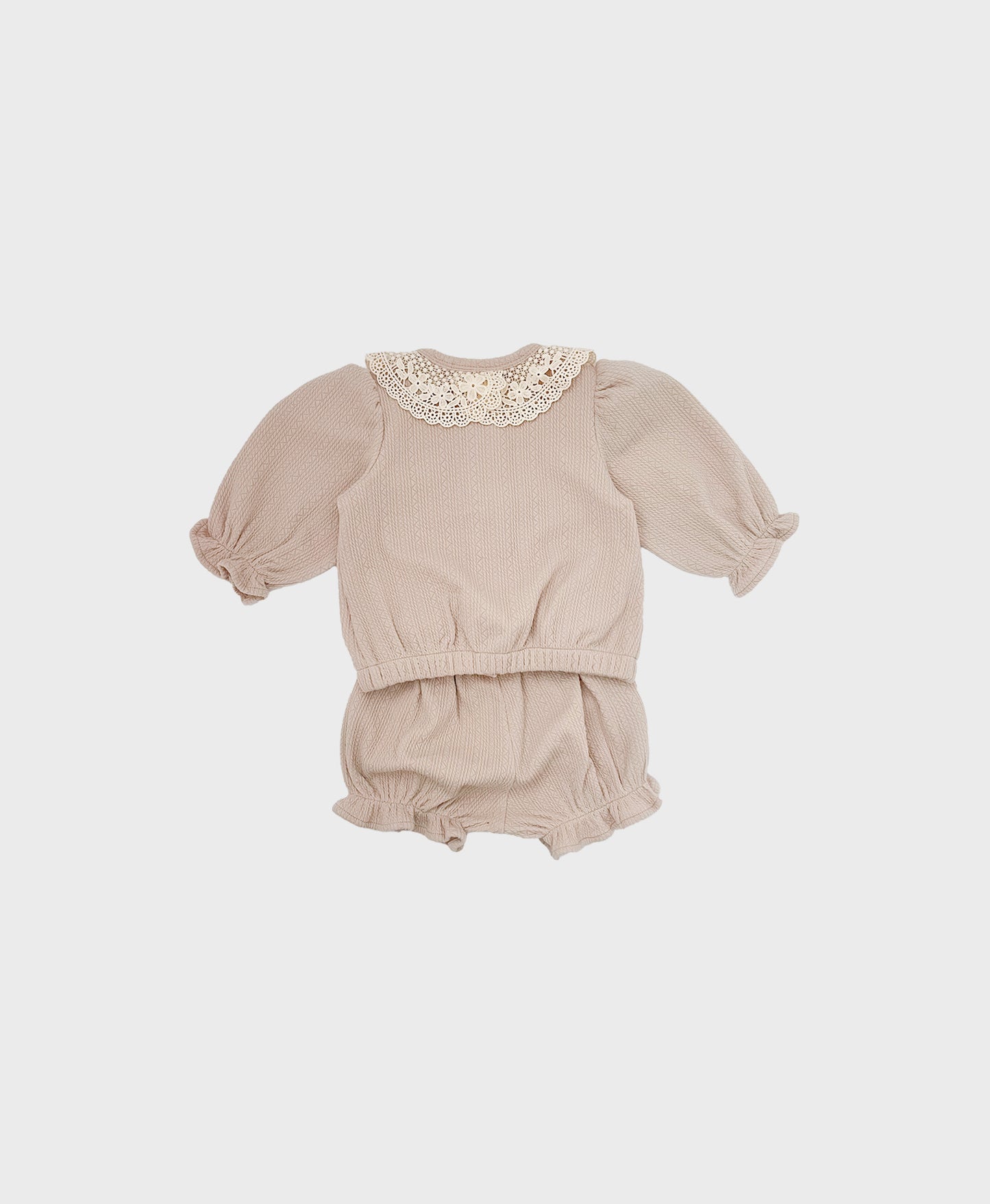 Light beige baby girl's cardigan with a white lace collar, ideal for a fall cardigan suit set in a baby boutique.
