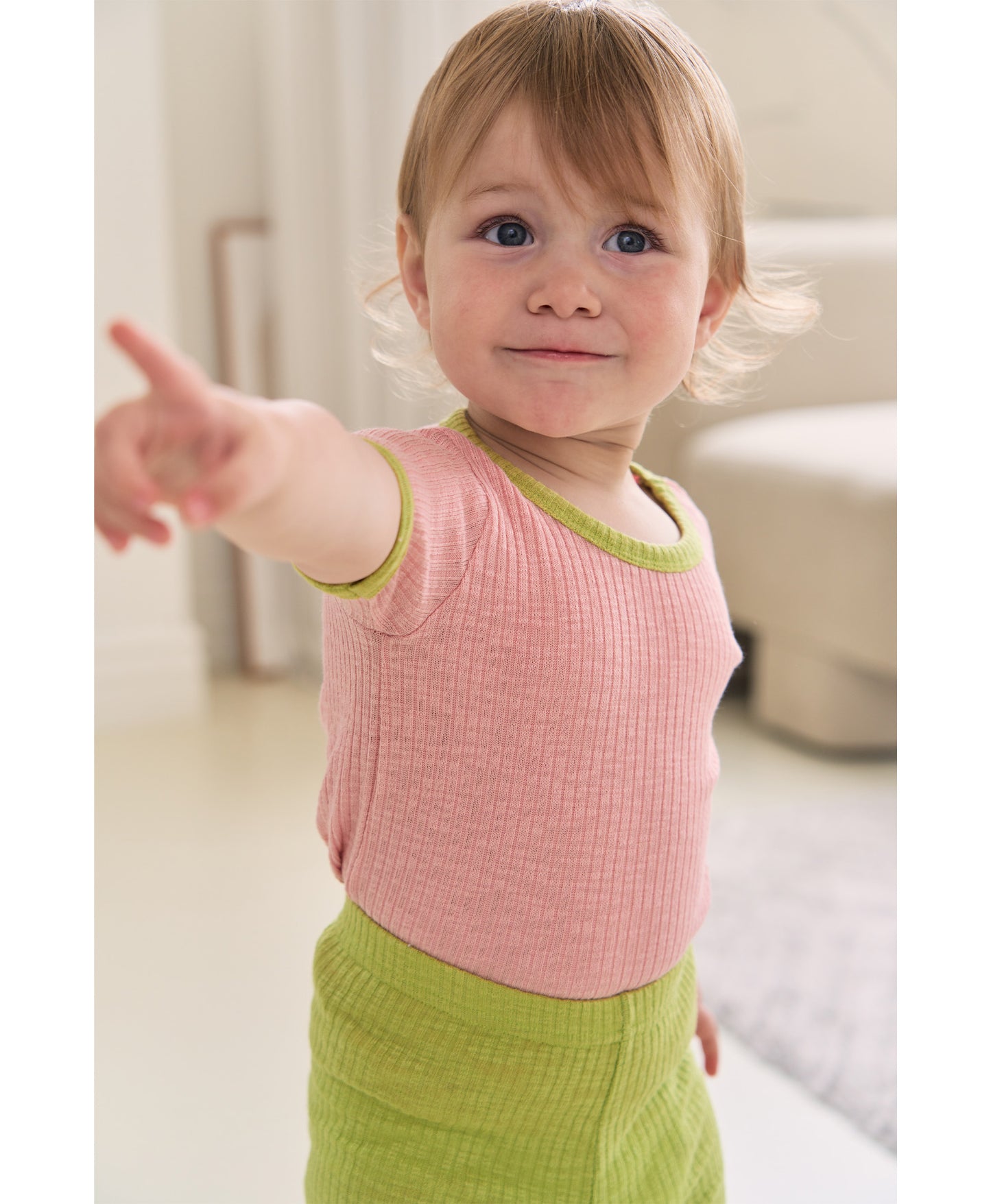 Unique baby clothes set with a mix of earthy and pastel tops and pants in green and pink