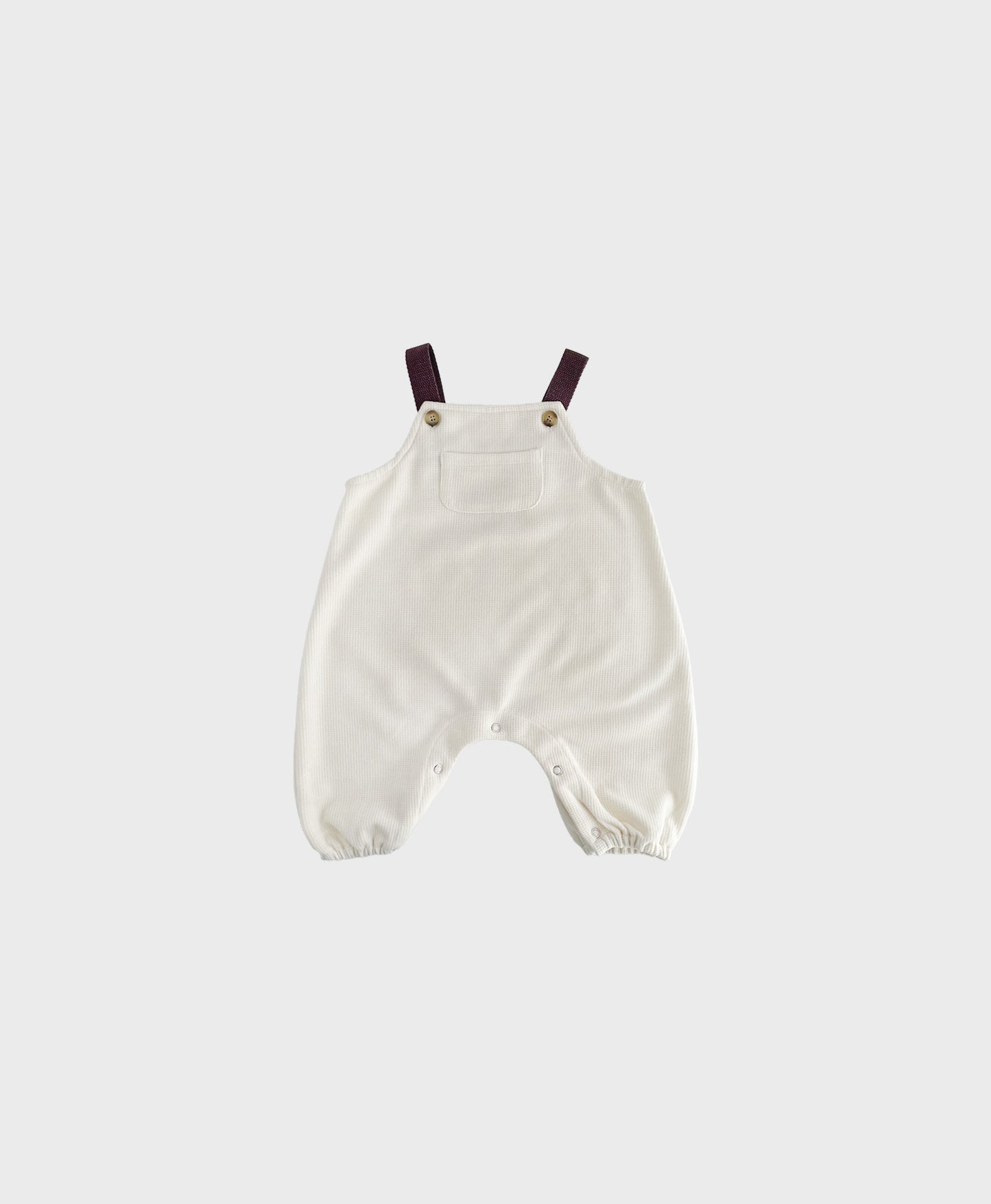 Ivory sleeveless overall with brown straps for hip baby boy with snap buttons.