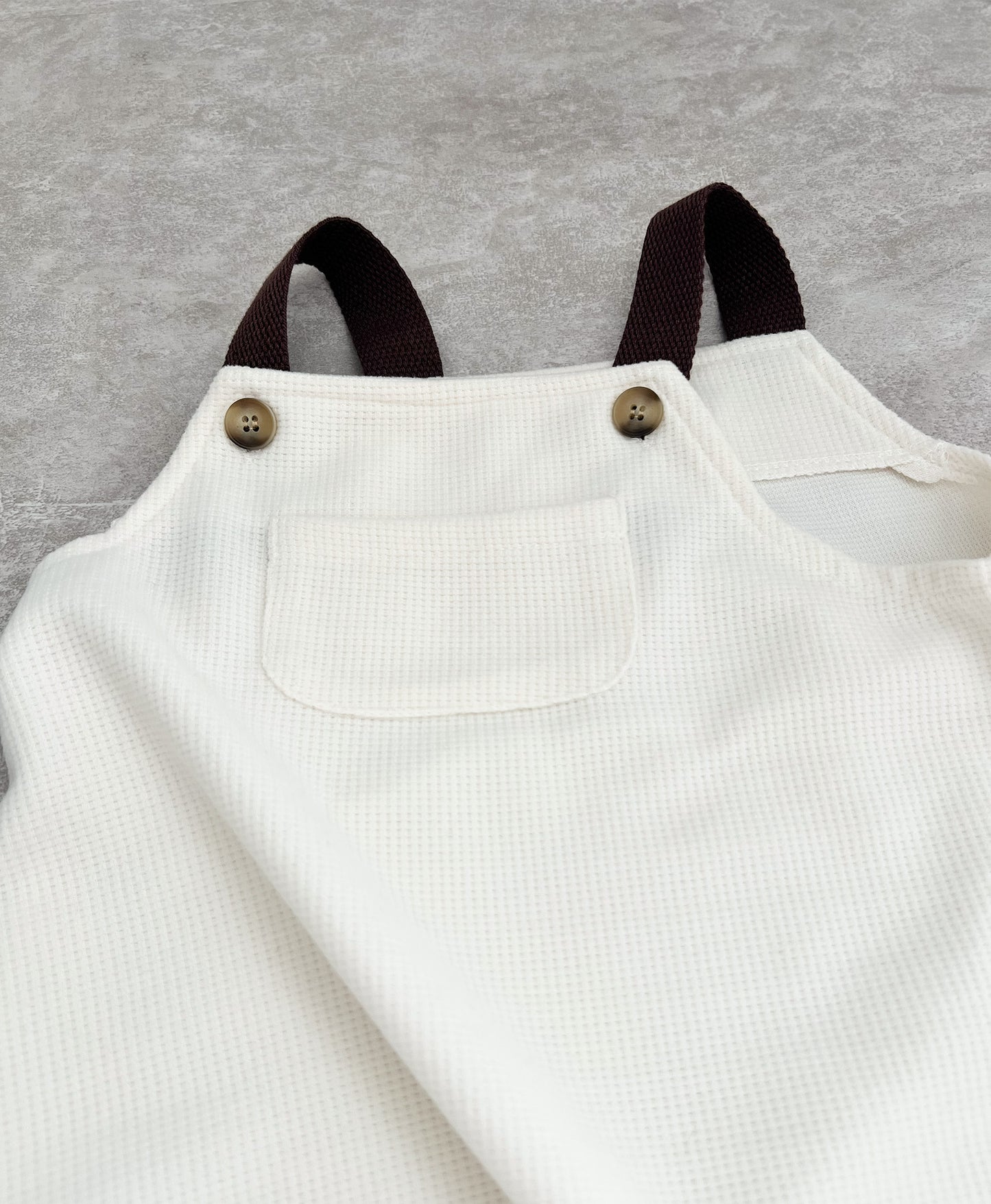 Brown strap sleeveless overall for hip baby boy with snap buttons in clutch..