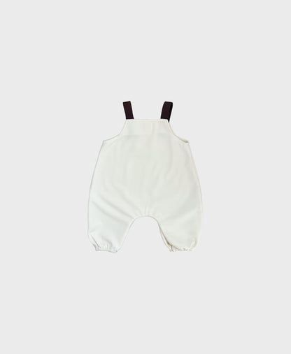 Hipster baby boy clothes: Ivory sleeveless overall with brown straps.