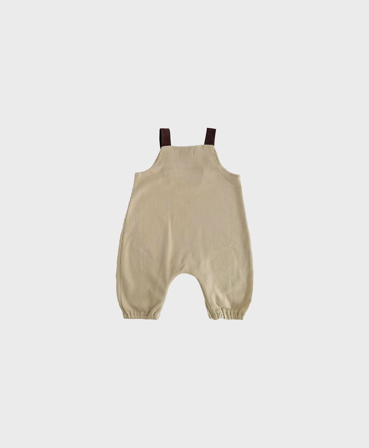 Hipster baby boy clothes: Beige sleeveless overall with brown straps.
