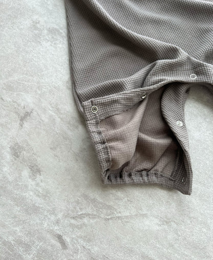 Hipster baby boy clothes: details of brown sleeveless overall with easy snap buttons.