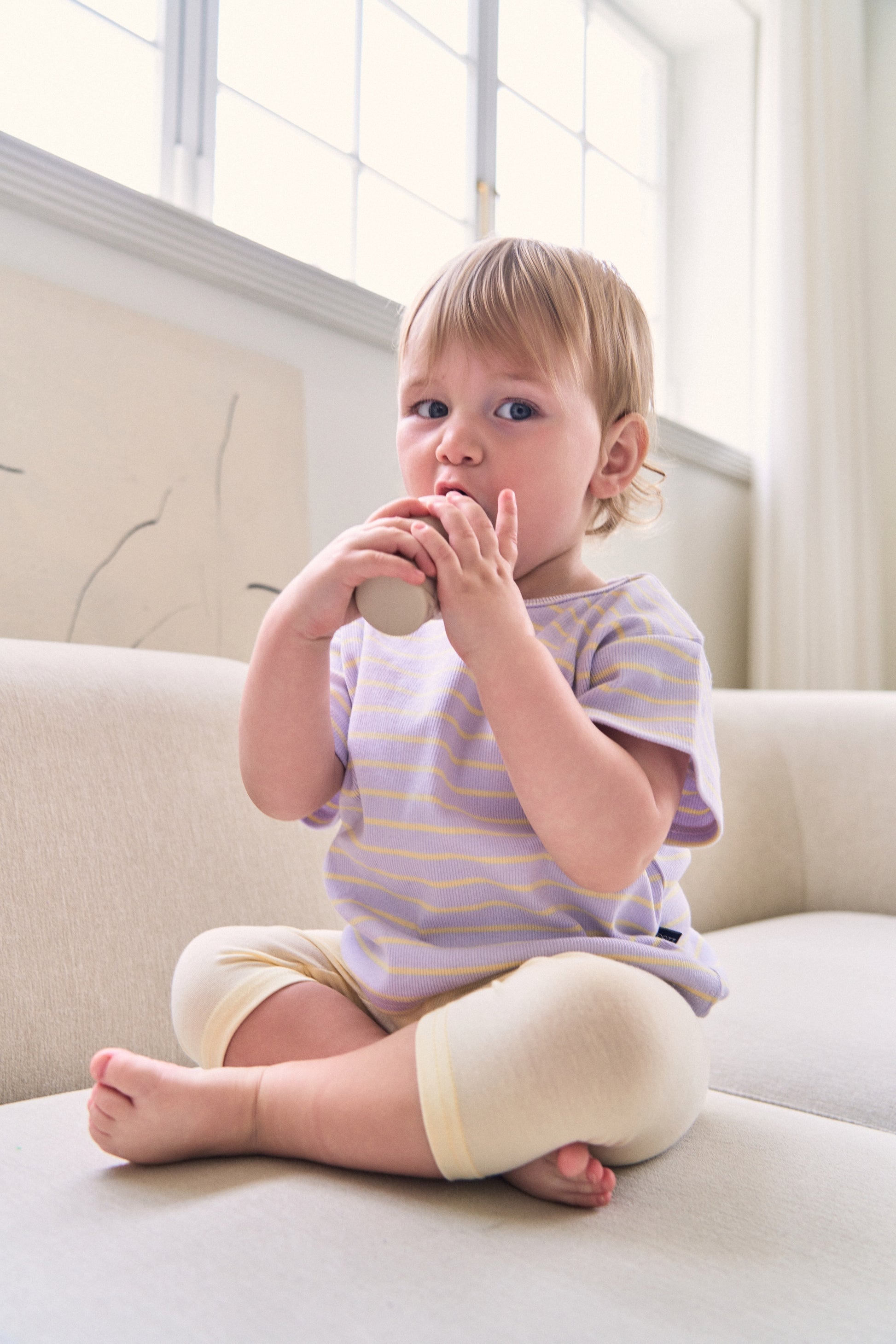Baby boy in cute toddler boy clothes on modern sofa