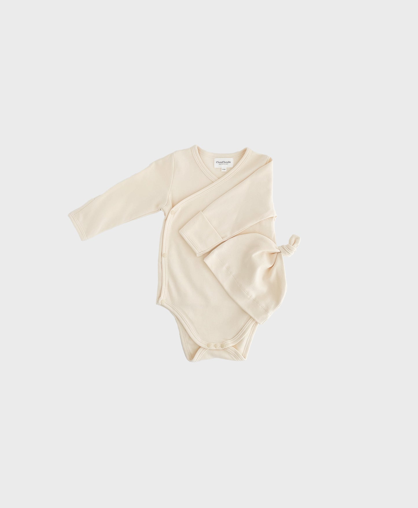 Ivory newborn set with hat, featuring kimono one piece design with snap buttons on crotch.