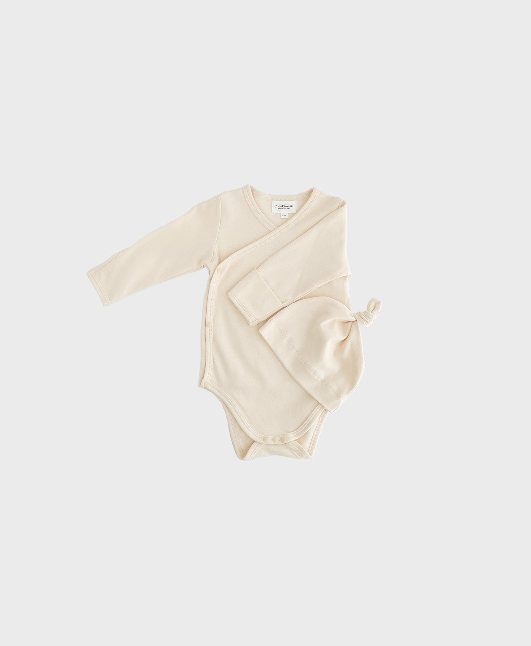 Ivory newborn set with hat, featuring kimono one piece design with snap buttons on crotch.