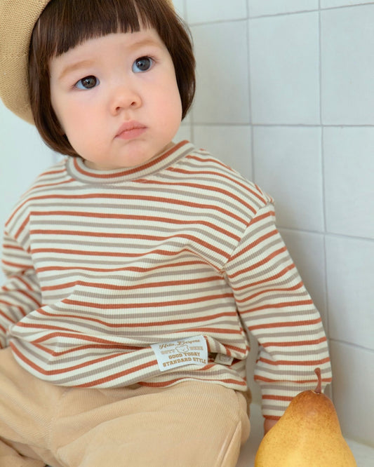 Child wearing a striped shirt and beige pants
