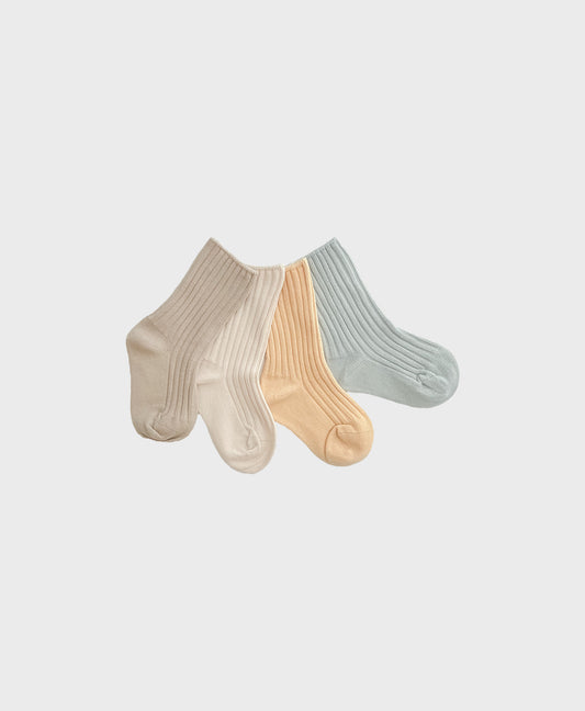 Five pairs of ribbed socks in blue, beige, apricot, and brown adding a touch to matching baby and toddler outfits.