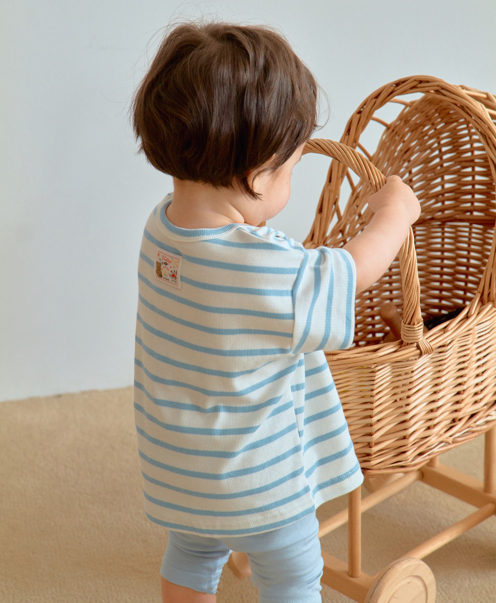 Baby boy in cute toddler boy clothes reaching for a toy