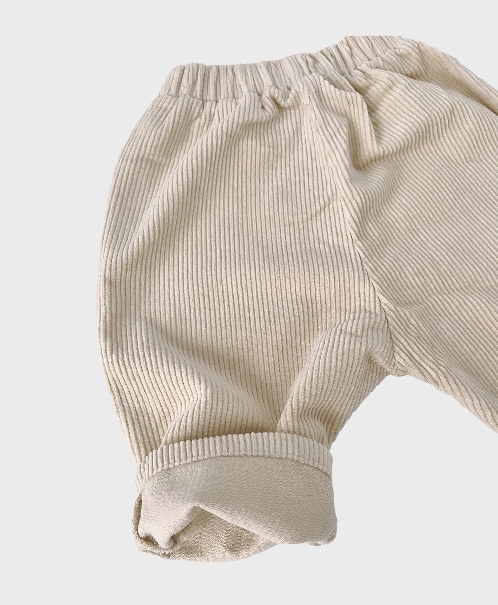 Creme baby corduroy pants with large front pockets, designed for baby boy dedication clothes, and hip baby boy clothing