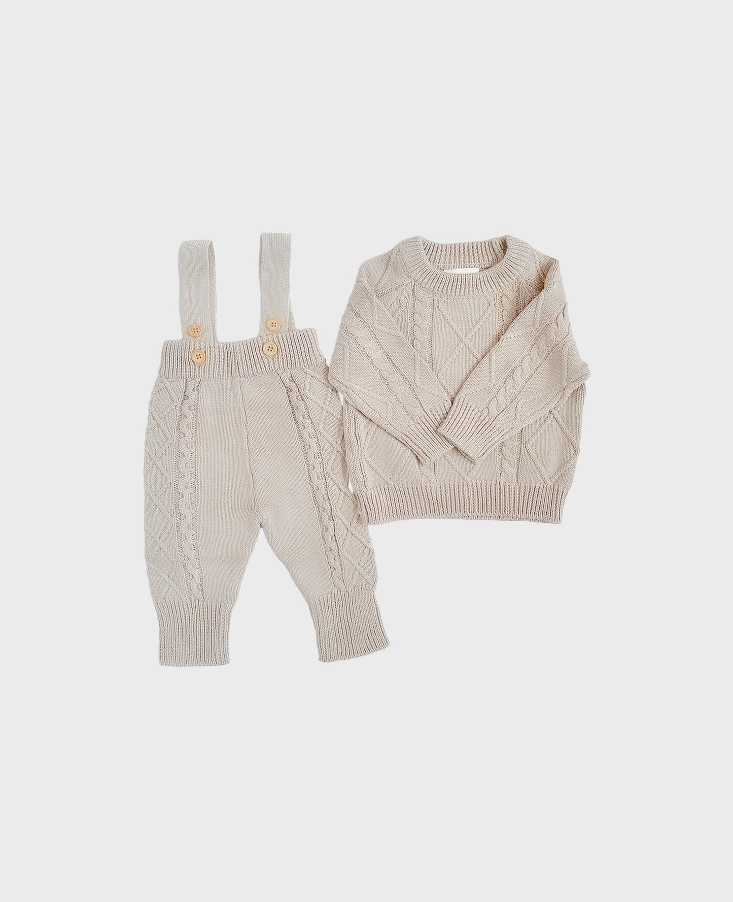 Grey colored knitted baby onesie with cable knit patterns and suspenders for baby boy boutique clothing