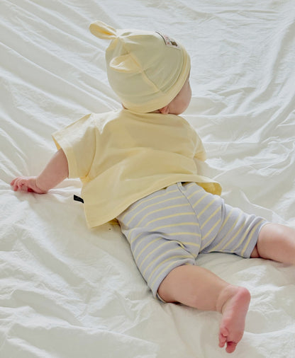 baby wearing soft boys boutique clothing, laying on the bed