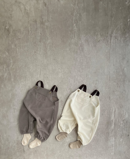 A sleeveless overall with brown straps, perfect for hip baby boys. Features snap buttons for easy dressing. Hipster baby boy clothes.